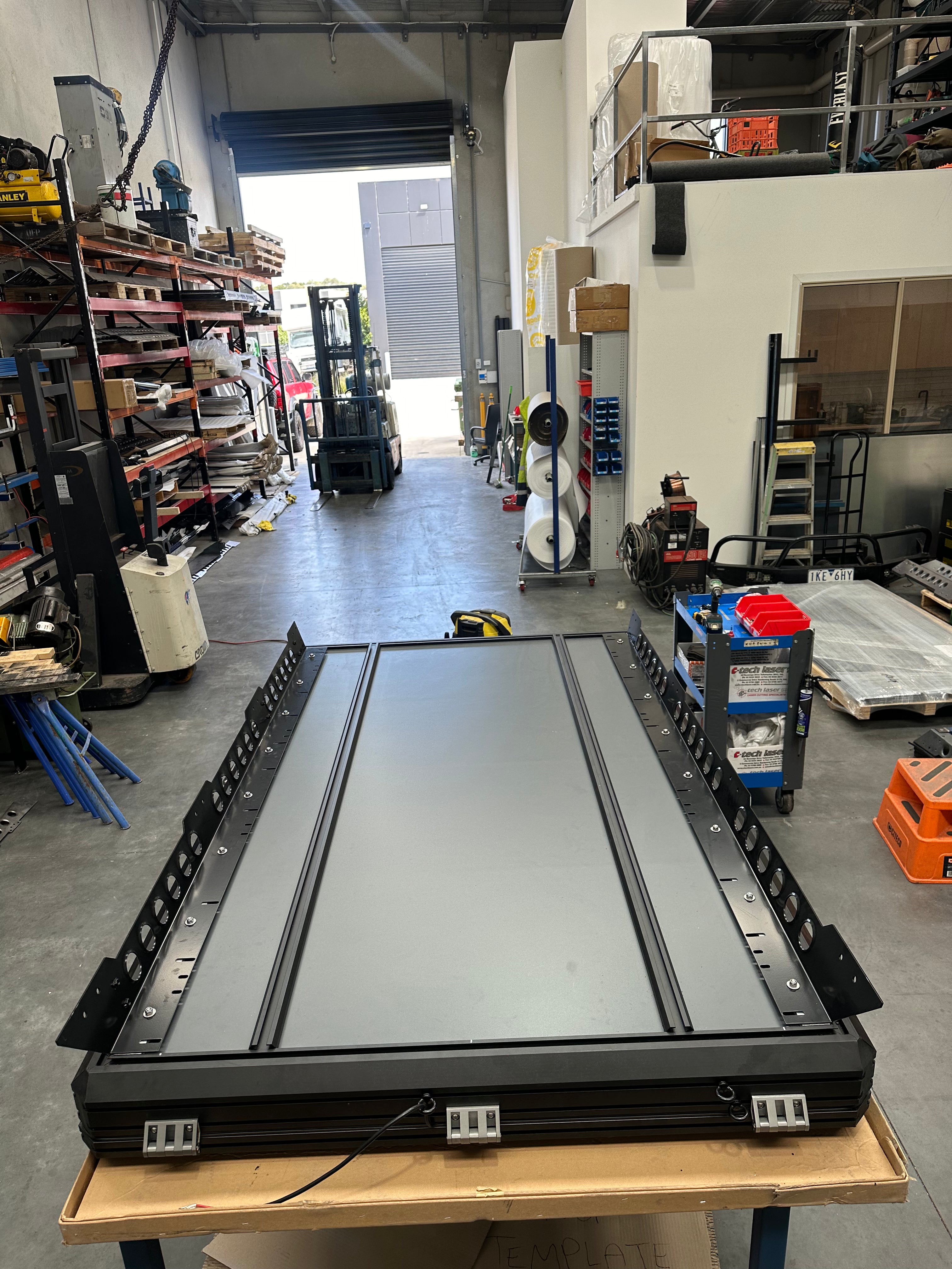 This is an image of a black steel roof rack panel by Tier One Metalworks inside an Australian 4x4 workshop