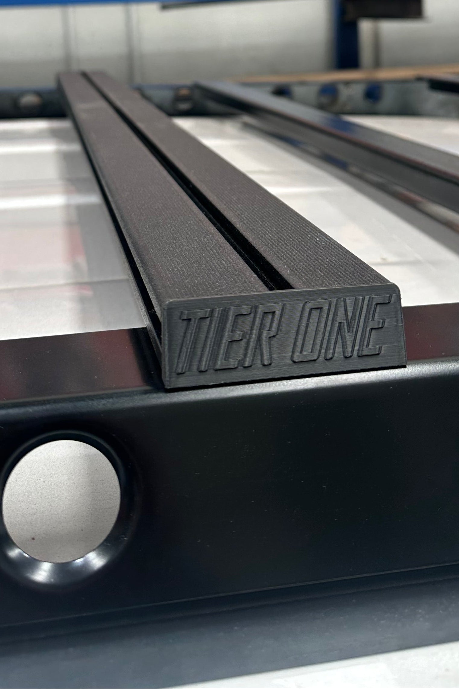 This is an image of black Tier One Metalworks roof rack rails close-up on a white vehicle roof