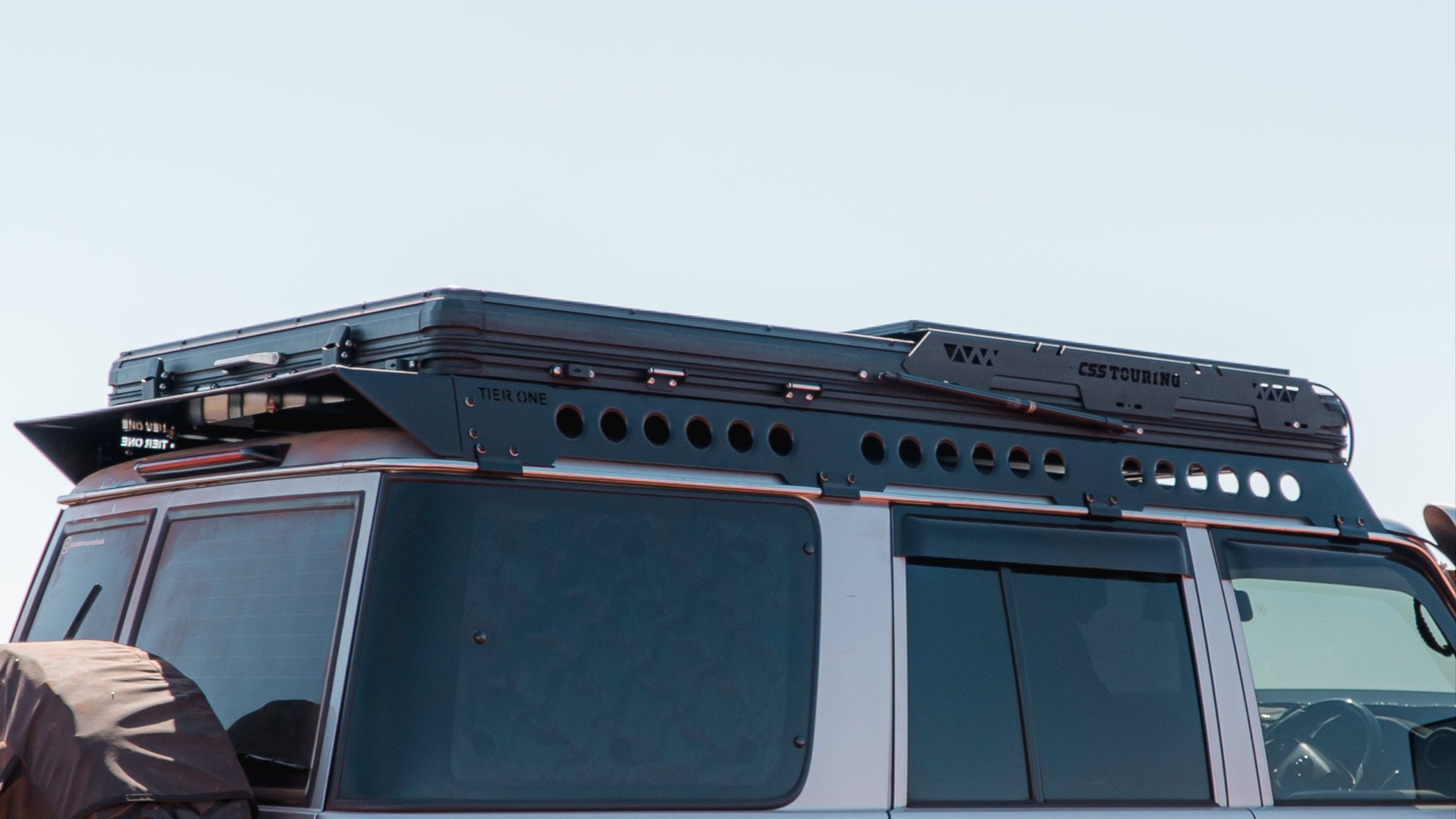 This is an image of a silver 4x4 with Tier One Metalworks Roof Racks and CSS Touring rooftop tent