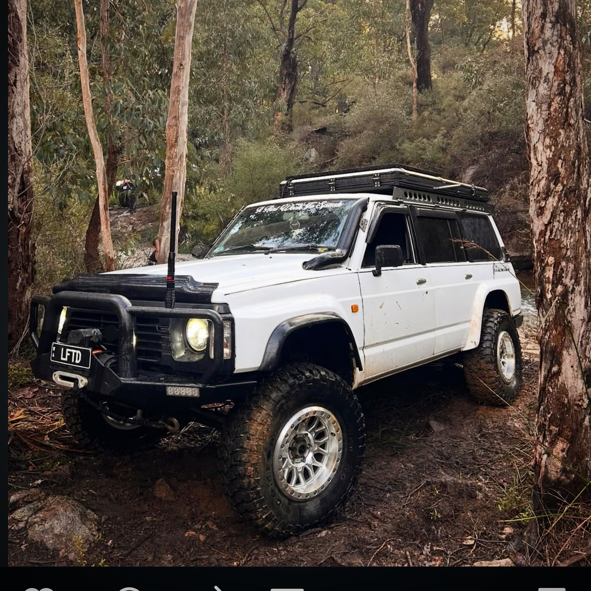 This is an image of a white Nissan Patrol 4WD with Tier One Metalworks Roof Racks & Rails in Australian bushland