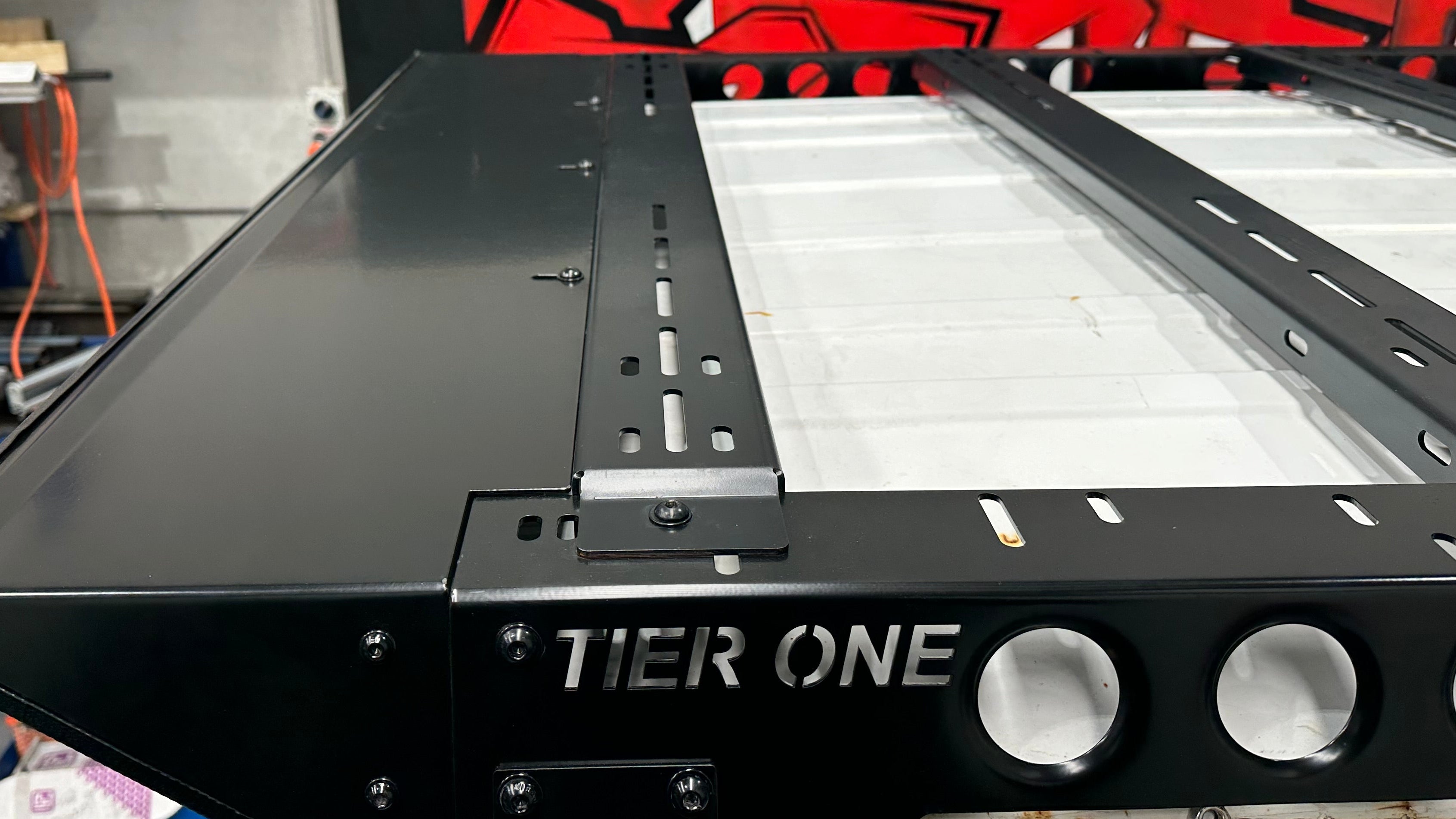 This is an image of a Tier One Metalworks black steel roof rack in a workshop setting